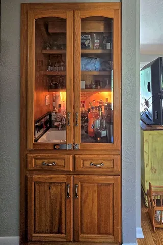 a bedroom with a bed painting on wall and a large window