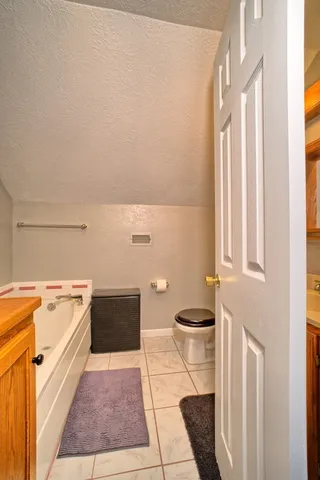 a bathroom with a toilet a sink and a window