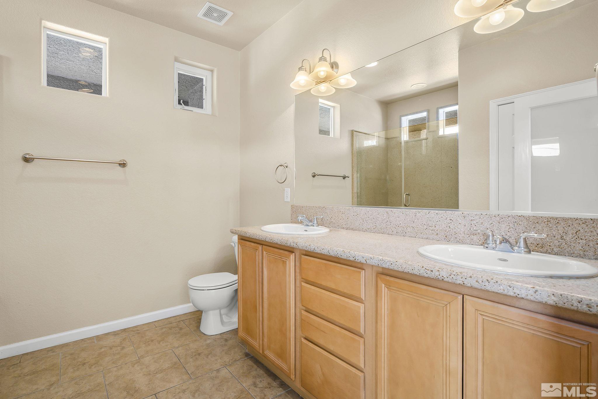 1026 Floral Ridge Way Sparks, NV 89436 - Photo 12 of 22 a bathroom with a granite countertop sink a toilet and a mirror