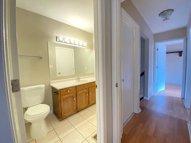a spacious bathroom with a granite countertop toilet sink and mirror
