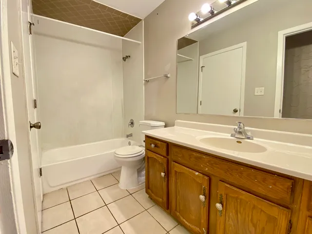 a bathroom with a granite countertop sink toilet a shower and a mirror