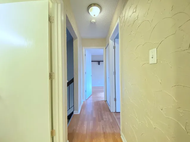 a view of a hallway with wooden floor
