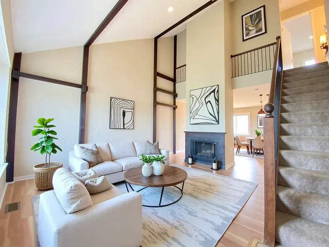 a living room with furniture a fireplace and a chandelier