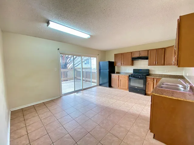 a large kitchen with a stove a sink dishwasher and a refrigerator