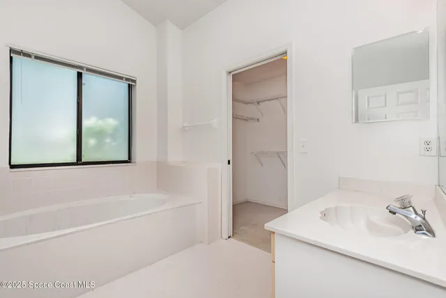 a white bath tub sitting next to a white sink