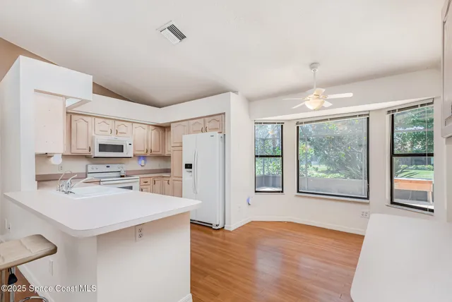 a kitchen with stainless steel appliances a sink cabinets and wooden floor