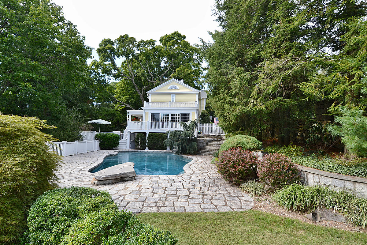 112 Brushy Ridge Road New Canaan, CT 06840 - Photo 32 of 45 a front view of a house with a yard garage and outdoor seating