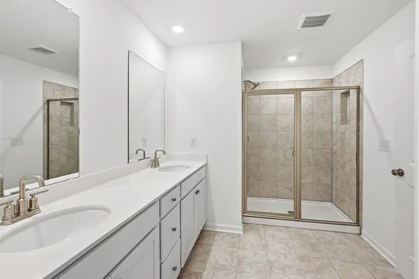 a bathroom with double sink and a mirror
