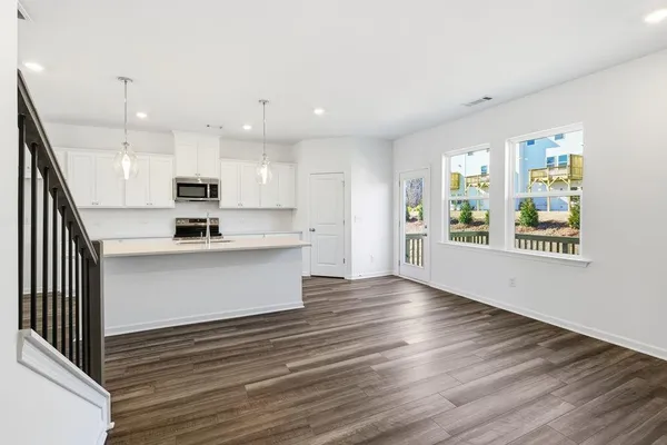 a view of kitchen with wooden floor and electronic appliances