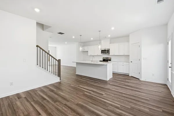 a view of kitchen with wooden floor and electronic appliances