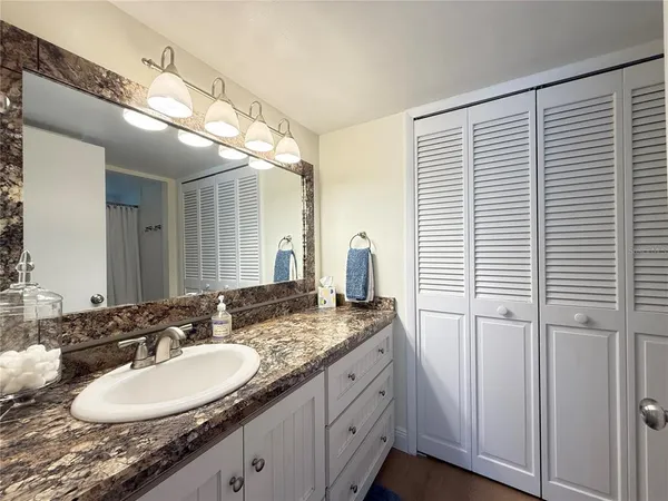 a bathroom with a granite countertop sink and a mirror