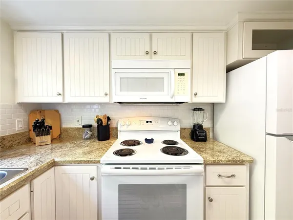 a kitchen with a sink a stove and cabinets