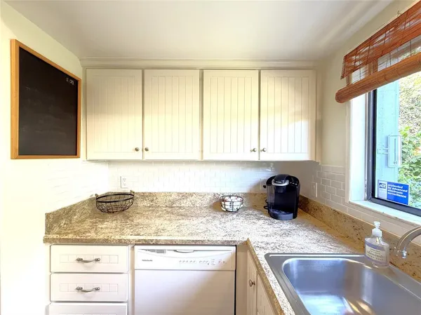 a kitchen with granite countertop a sink and a stove top oven