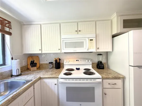 a kitchen with a sink a stove and cabinets
