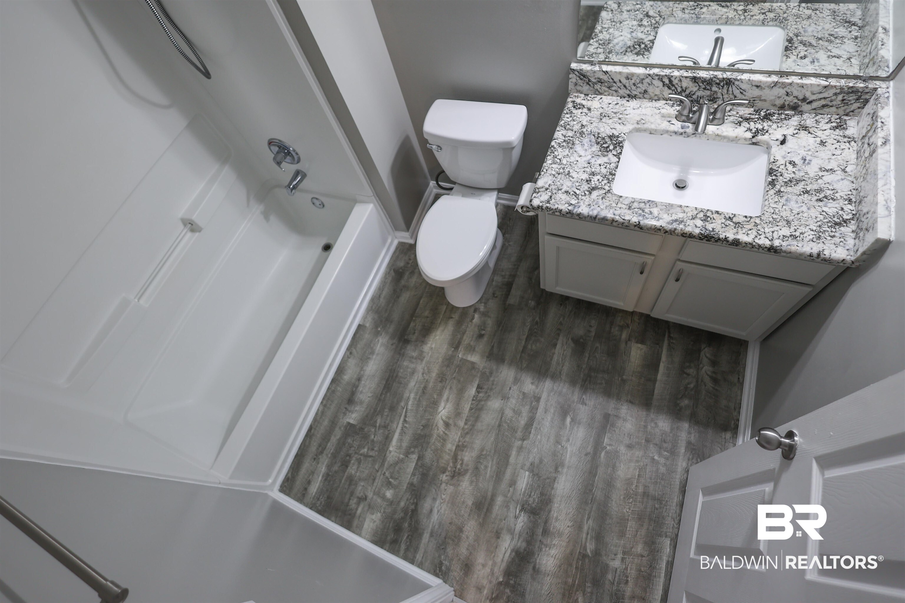 1517 Regency Road, Unit 125 Gulf Shores, AL 36542 - Photo 20 of 26 Bathroom with vanity, washtub / shower combination, and dark wood-style floors