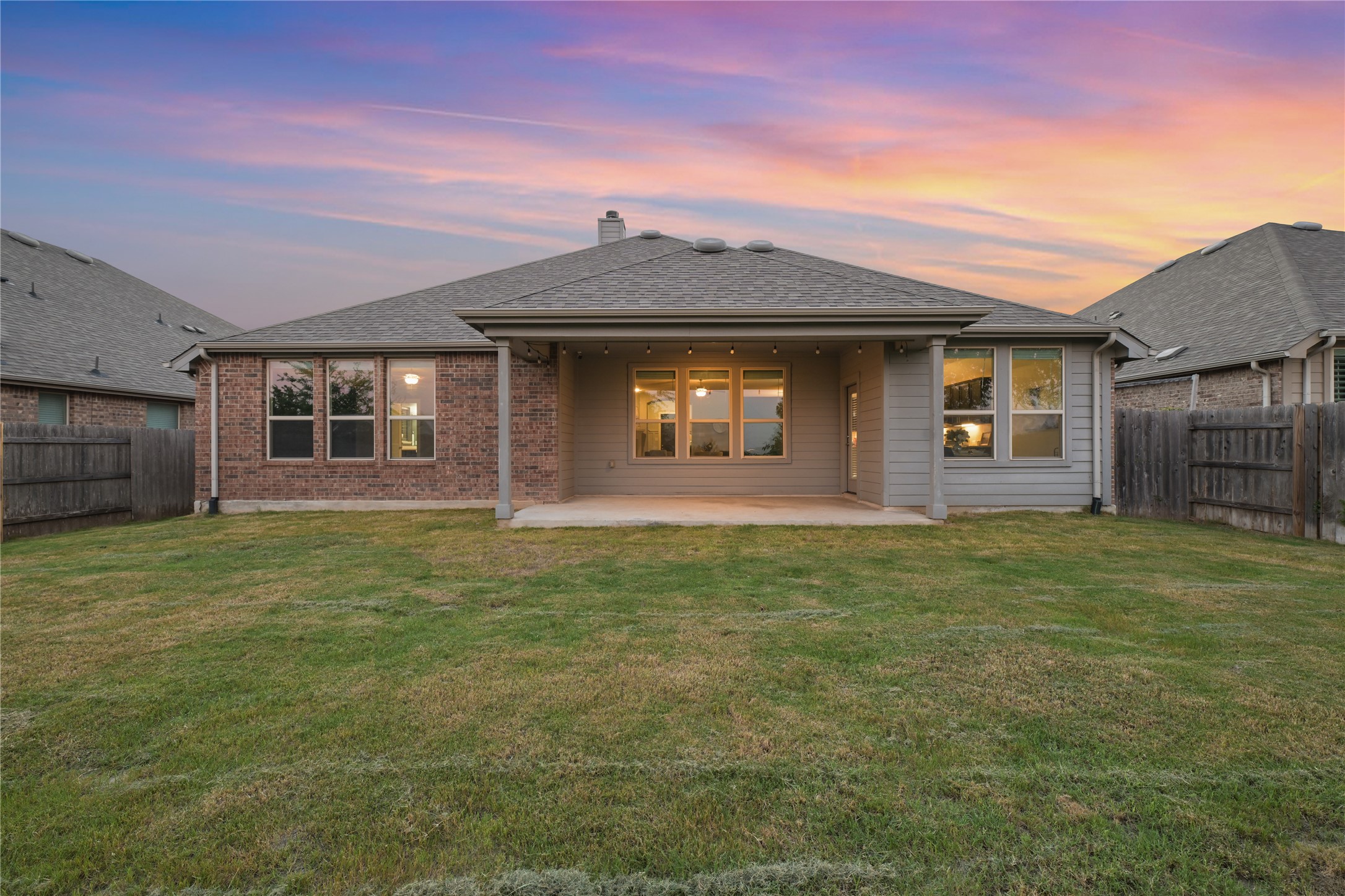 188 Nautical Loop Kyle, TX 78640 - Photo 29 of 38 A fenced backyard offers a concrete patio and a picturesque sunset view.