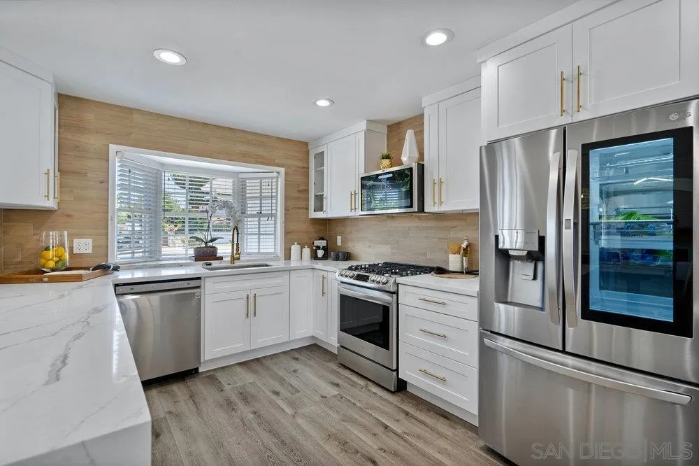 5771 Rutgers Road La Jolla, CA 92037 - Photo 27 of 75 a kitchen with stainless steel appliances granite countertop a refrigerator a stove top oven a sink and dishwasher with wooden floor