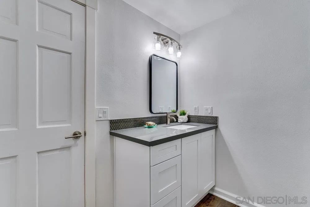5771 Rutgers Road La Jolla, CA 92037 - Photo 42 of 75 a bathroom with a granite countertop sink and a mirror