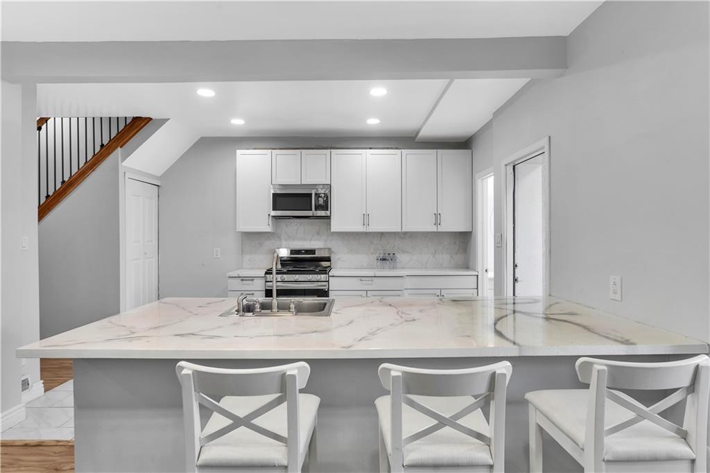 25 Clearview Avenue Duquesne, PA 15110 - Photo 13 of 33 a kitchen with kitchen island a stove a table and chairs in it