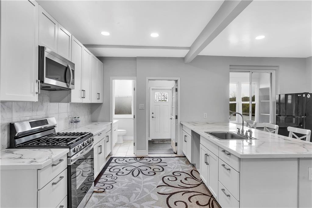 25 Clearview Avenue Duquesne, PA 15110 - Photo 17 of 33 a kitchen with stainless steel appliances a sink stove and cabinets