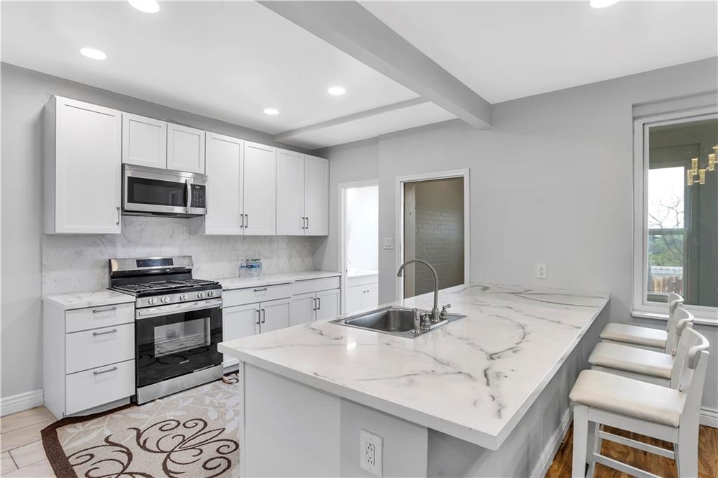 25 Clearview Avenue Duquesne, PA 15110 - Photo 18 of 33 a kitchen with granite countertop white cabinets and black appliances