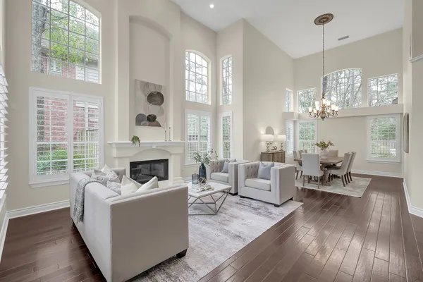 a living room with furniture large window and wooden floor