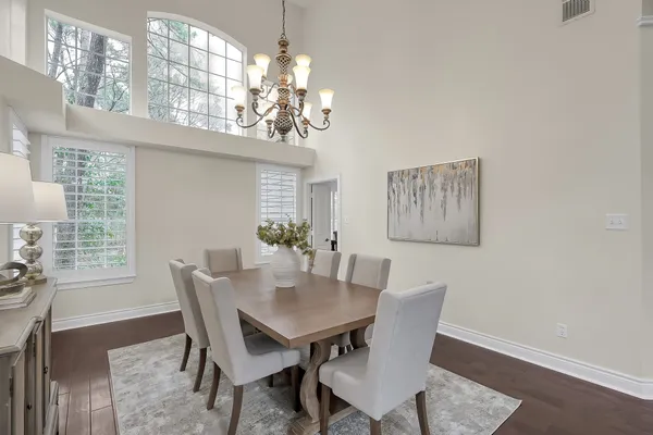 a kitchen with stainless steel appliances granite countertop a table chairs refrigerator and sink