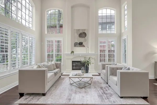 a living room with furniture a fireplace and a large window