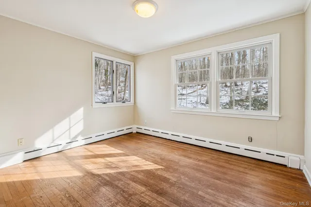 a view of a room with wooden floor and a window