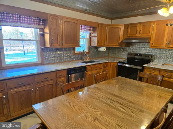 a kitchen with stainless steel appliances a sink dishwasher stove and cabinets