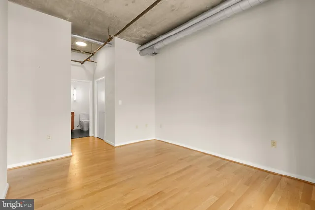 a view of a big room with wooden floor and windows
