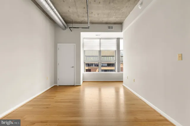 a view of a room with wooden floor and a window