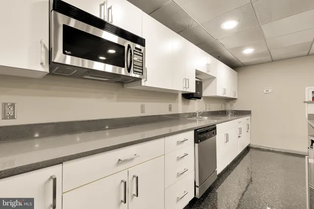 a kitchen with stainless steel appliances granite countertop a sink and a microwave