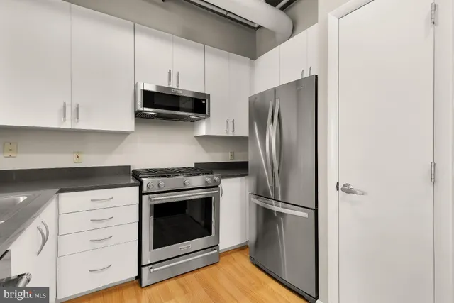 a kitchen with stainless steel appliances white cabinets and a refrigerator