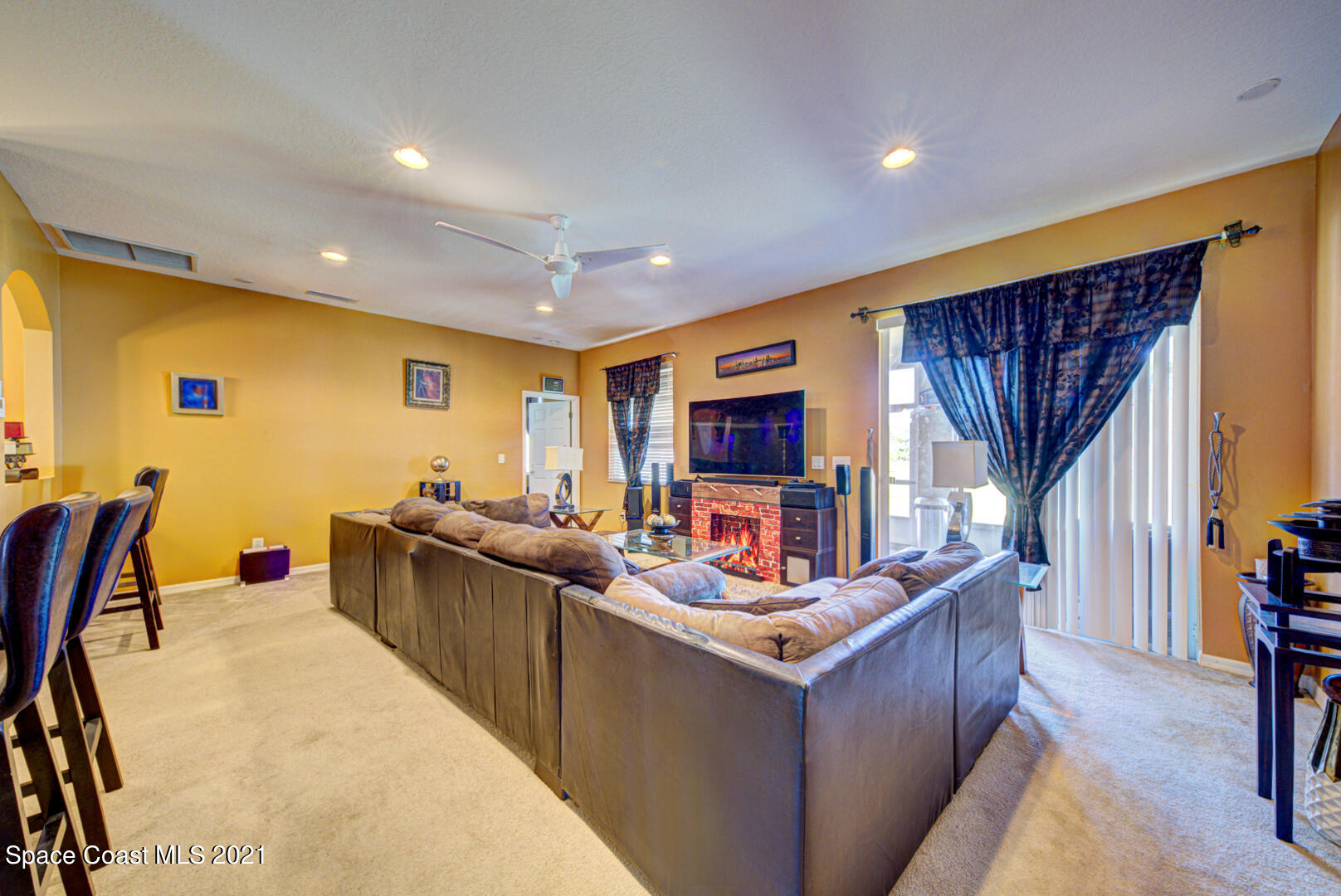 1483 Wakefield Road Southeast Palm Bay, FL 32909 - Photo 18 of 42 a living room with furniture a flat screen tv and a refrigerator