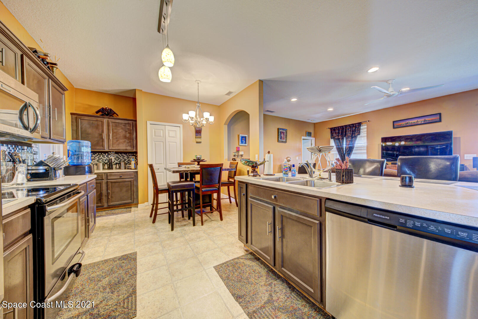 1483 Wakefield Road Southeast Palm Bay, FL 32909 - Photo 21 of 42 a kitchen with stainless steel appliances granite countertop a refrigerator a sink dishwasher a dining table and chairs with wooden floor