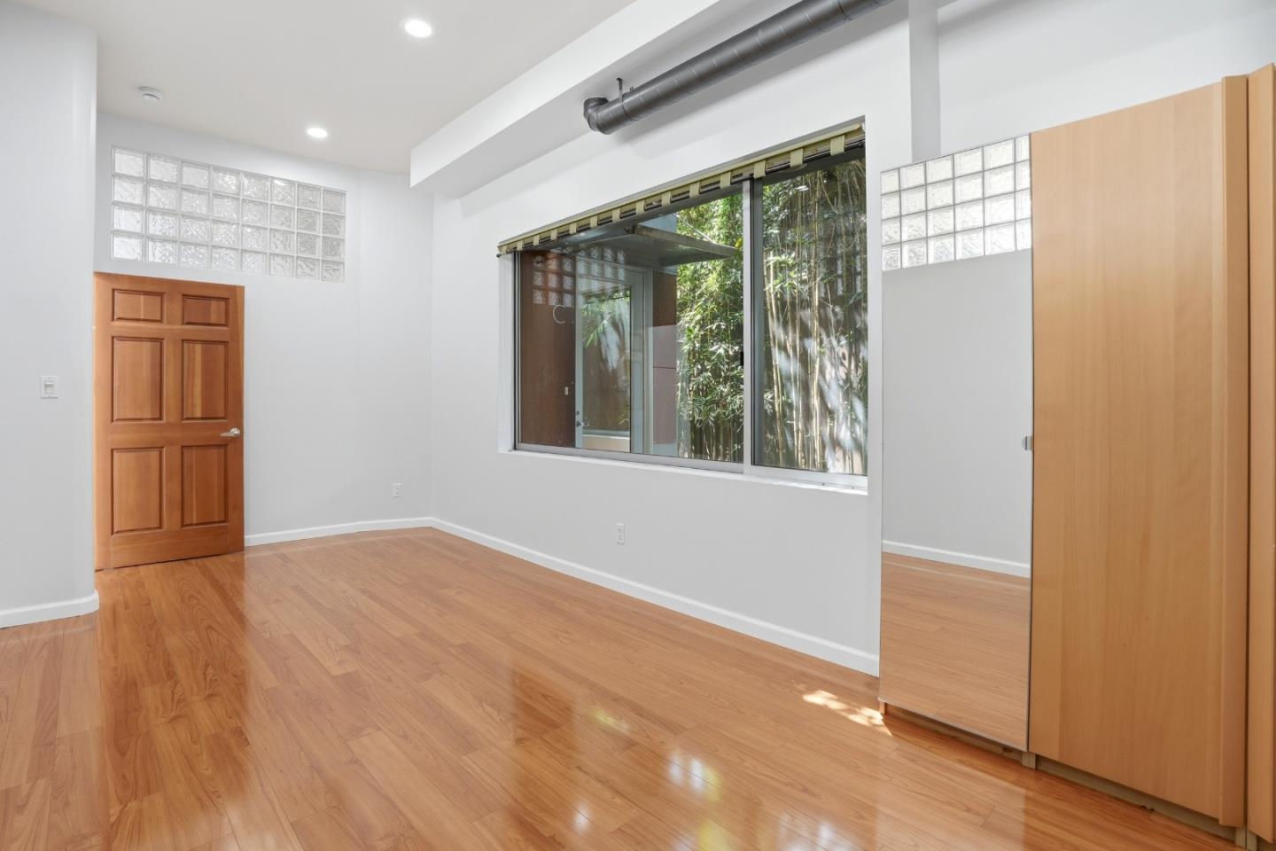 2709 Tenth Street, Unit C Berkeley, CA 94710 - Photo 13 of 44 a view of an empty room with wooden floor and a window