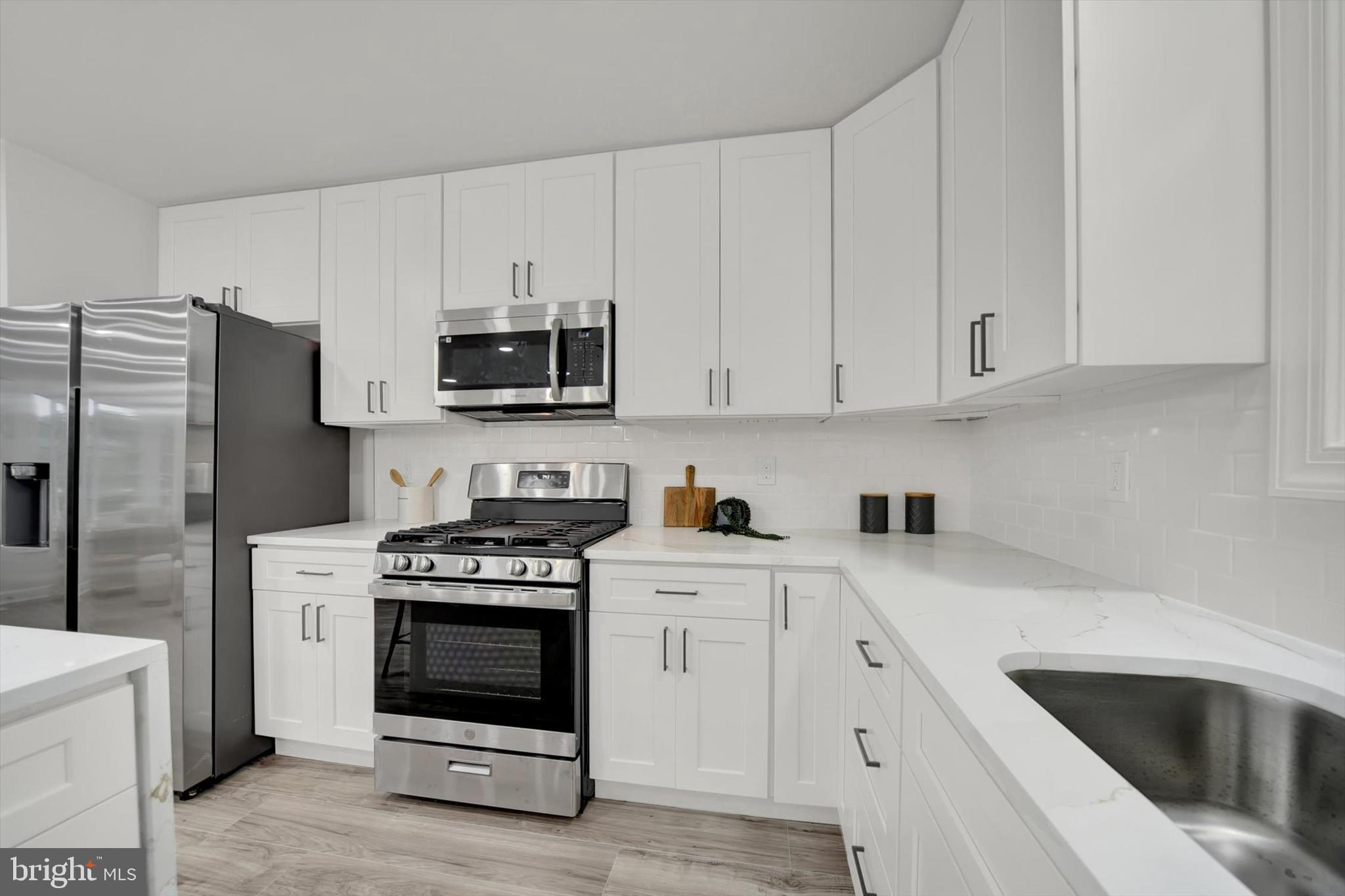 3808 Perryhurst Place Baltimore, MD 21236 - Photo 11 of 29 a kitchen with cabinets stainless steel appliances and a sink
