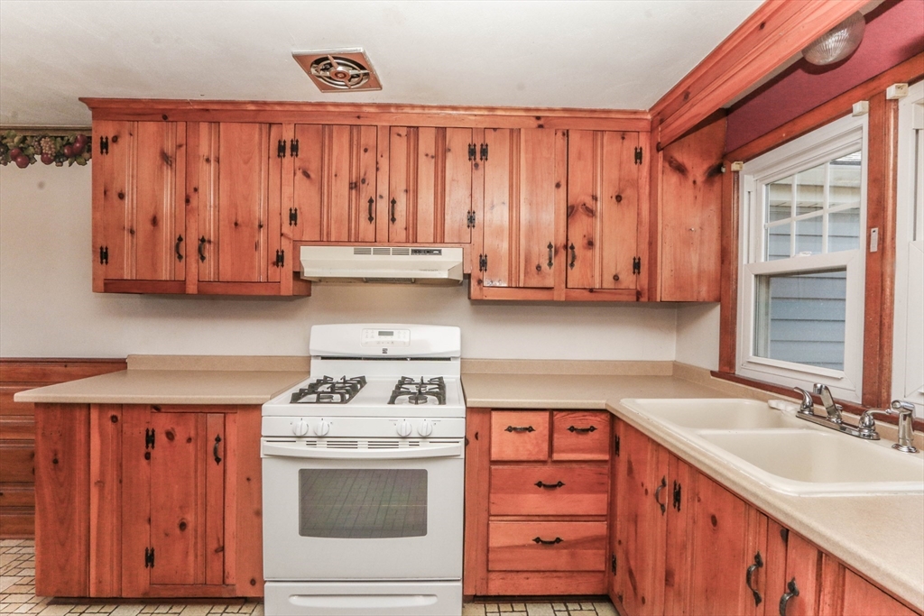 185 East Street Springfield, MA 01104 - Photo 13 of 26 a kitchen with wooden cabinets and a stove top oven