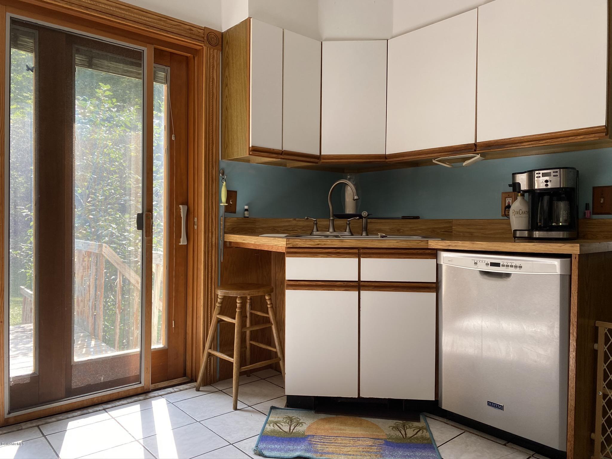 311 Swamp Road Richmond, MA 01201 - Photo 19 of 42 a kitchen with stainless steel appliances granite countertop a stove a sink and a refrigerator with wooden cabinets