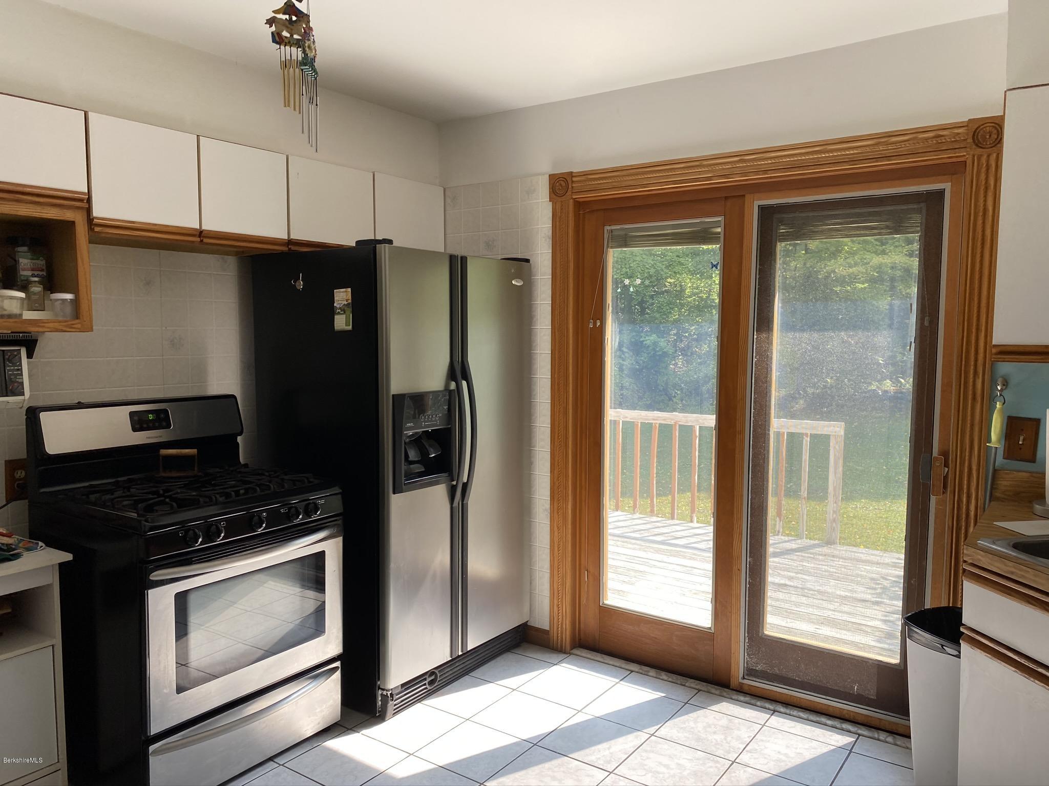 311 Swamp Road Richmond, MA 01201 - Photo 25 of 42 a kitchen with granite countertop a refrigerator and a stove top oven