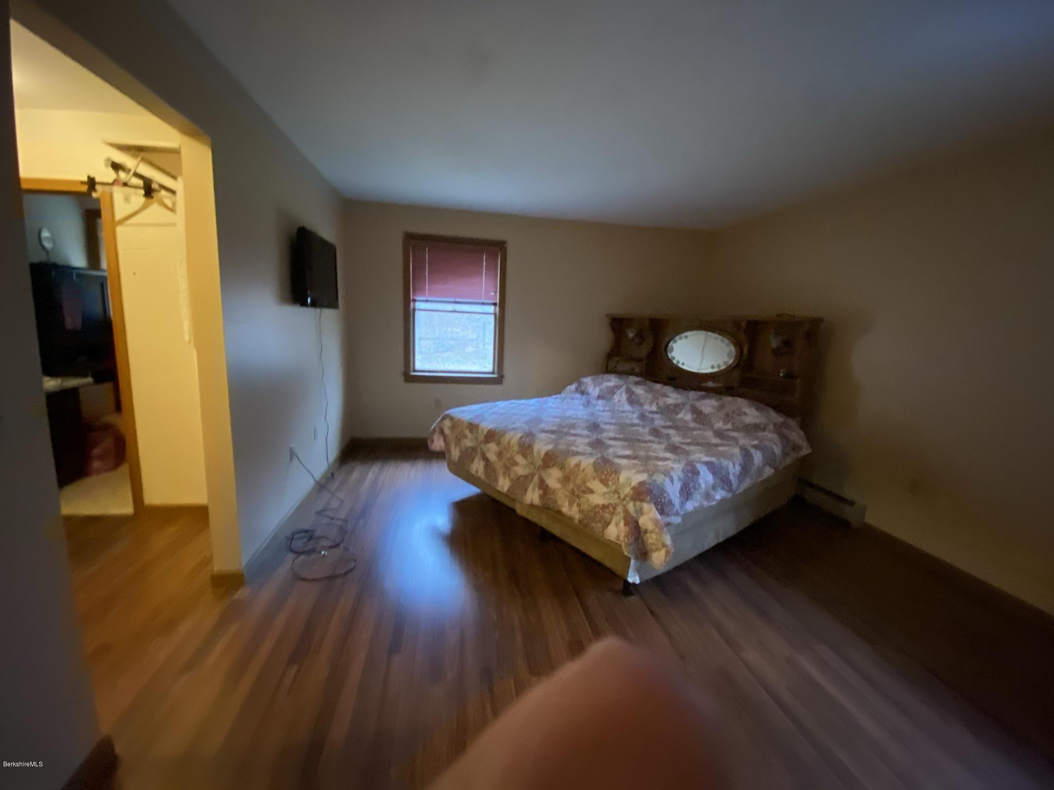 311 Swamp Road Richmond, MA 01201 - Photo 33 of 42 a bedroom with a bed and wooden floor