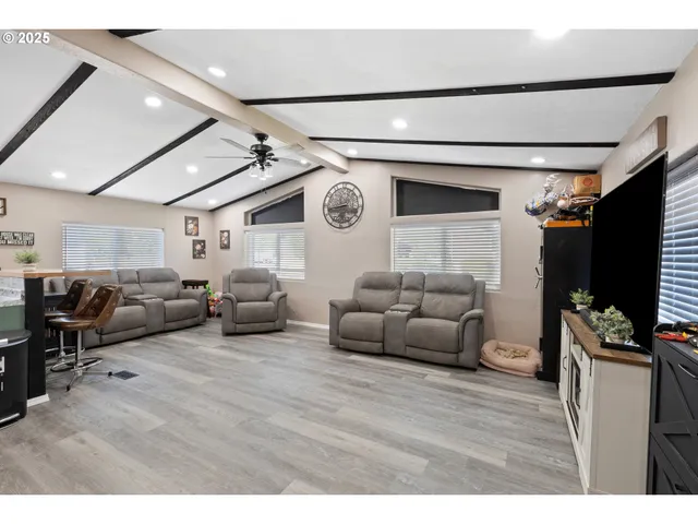 a living room with furniture a flat screen tv and a clock