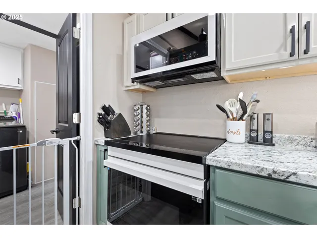 a kitchen with a microwave a stove and cabinets
