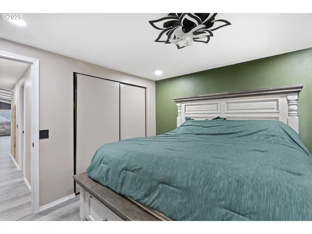 a bedroom with a bed and painting on the wall