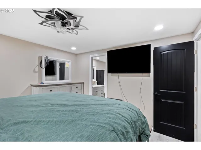 a living room with a flat screen tv and kitchen view