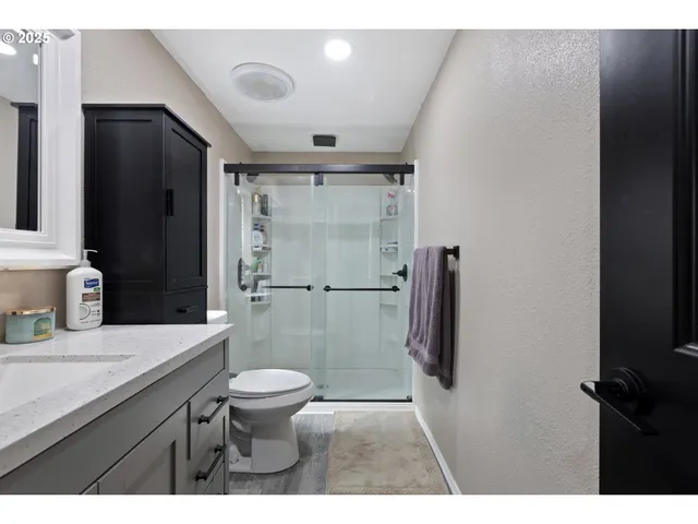 a bathroom with a granite countertop sink toilet and shower