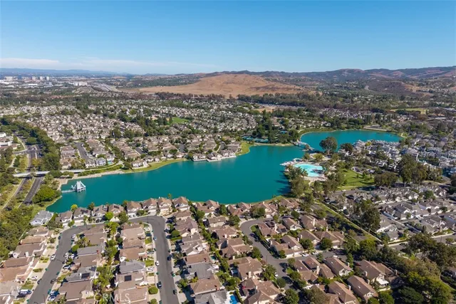 an aerial view of a residential houses with outdoor space and trees