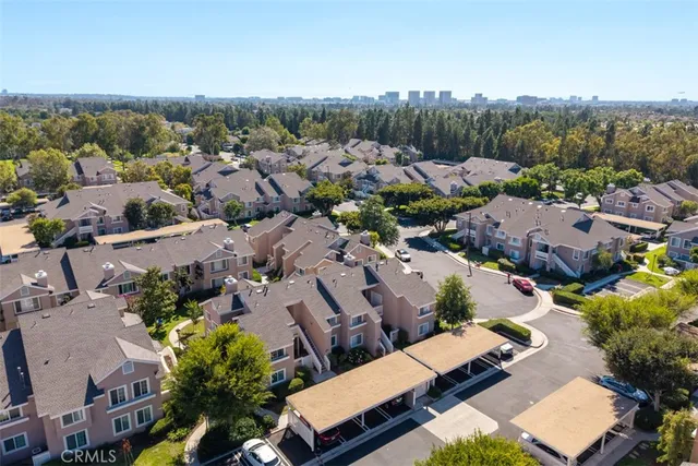 an aerial view of a city with lots of residential buildings and mountain view in back