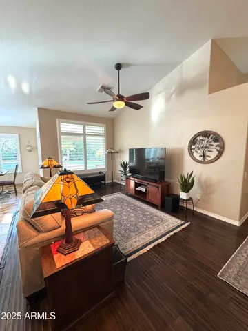 a living room with furniture a flat screen tv and a table